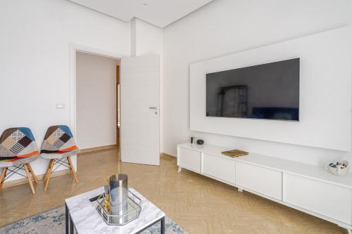 a white living room with a tv and chairs at Priori Loft & Terrace in Terni