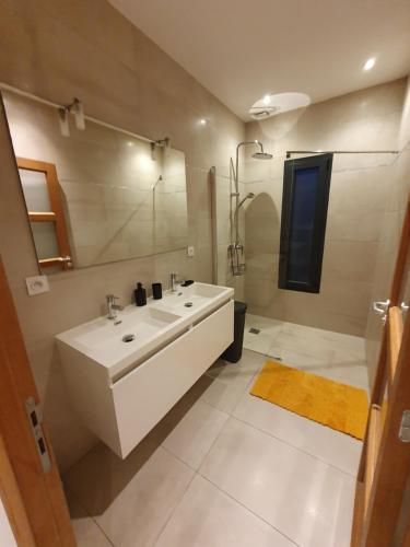 une salle de bain blanche avec un lavabo et un miroir dans l'établissement Villa Saint Michel, à Saint-Félix-de-Lodez