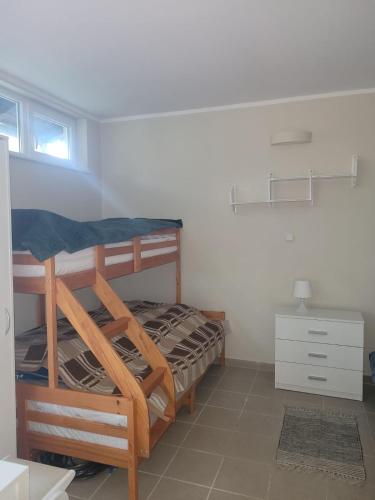 a bedroom with two bunk beds and a dresser at Siódma Wyspa in Łupawsko