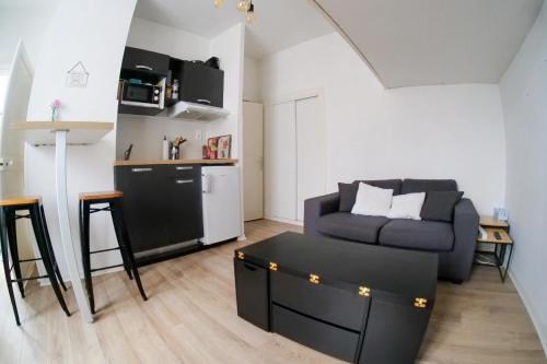 un salon avec un canapé et une cuisine dans l'établissement Studio douillet entre ville et océan - Etage 1 - Proche toutes commodités, à Les Sables-dʼOlonne