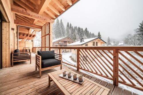 une terrasse en bois avec une chaise et une table dans l'établissement Apartment Rivulet, Châtel- by EMERALD STAY, à Châtel