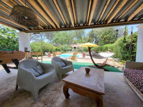 - un salon avec des chaises, une table et un parasol dans l'établissement Le Phoenix de Sainte Victoire, à Saint-Marc-Jaumegarde