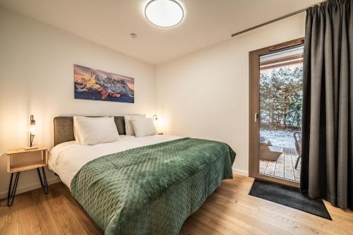 une chambre avec un lit et une grande fenêtre dans l'établissement Apartment Osmose 002, Châtel - by EMERALD STAY, à Châtel