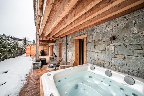 une baignoire dans une pièce avec un mur en pierre dans l'établissement Apartment Osmose 002, Châtel - by EMERALD STAY, à Châtel