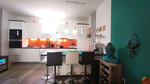 a kitchen with white cabinets and a table and chairs at Beach Garden Terrace Njivice in Njivice