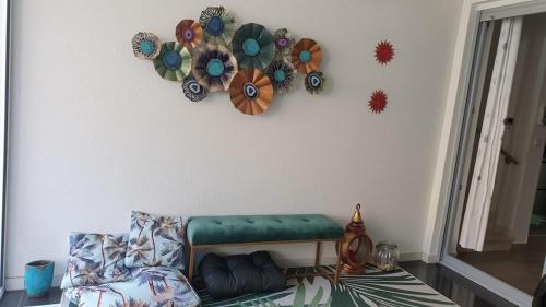 a living room with a green couch and decorations on the wall at Beach Garden Terrace Njivice in Njivice