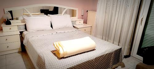 a bedroom with a bed with a white comforter at Park Apartment in Xanthi