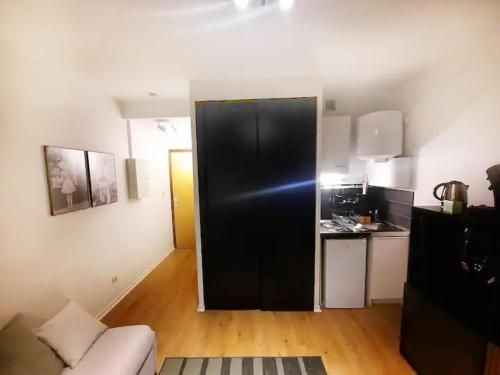 - une cuisine avec un réfrigérateur noir dans le salon dans l'établissement Le Garibaldi, à Dijon