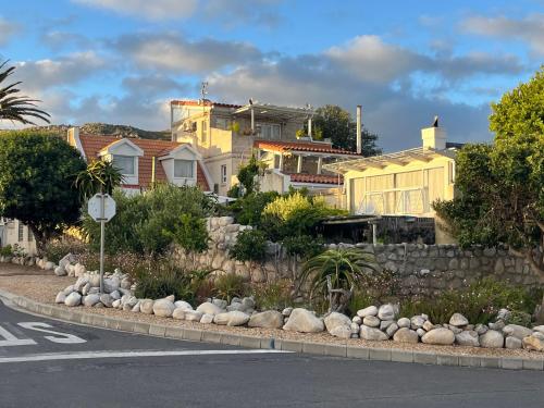 a road with a bunch of rocks and houses at Storyhouse in Kommetjie in Kommetjie