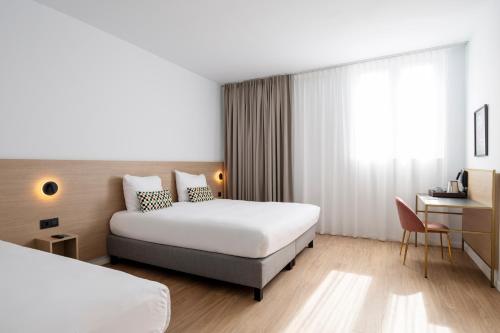 a hotel room with two beds and a desk at Jill Hotel Brussels in Brussels