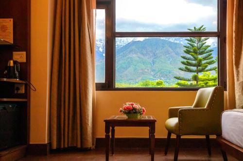 a room with a window with a view of a mountain at White Ridge Hotel in Dharamshala