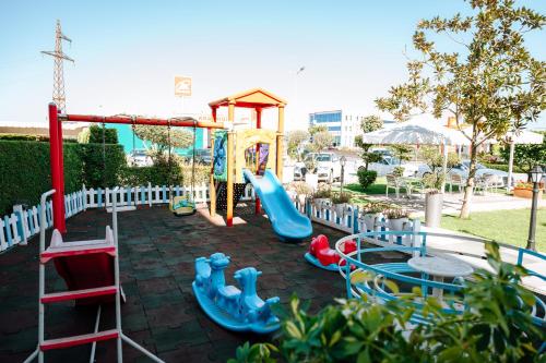 a playground with a slide and a swing set at Hotel Delta in Durrës