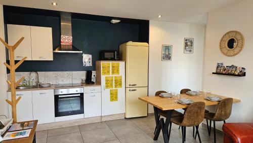 une cuisine avec une table en bois et un réfrigérateur dans l'établissement Le gîte de Soso Centre le Fuilet, à Le Fuilet