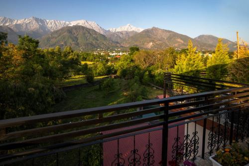 a balcony with a view of a mountain range at White Ridge Hotel in Dharamshala