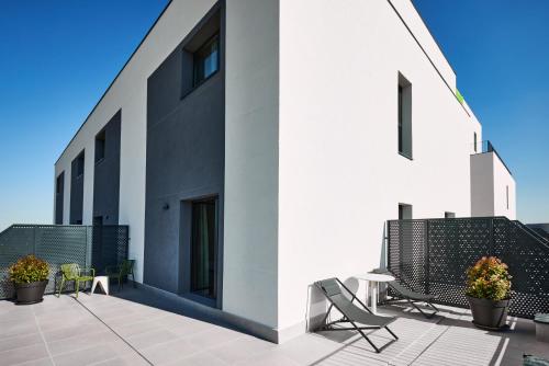 a patio with two chairs and a table on a building at Ibis Styles Madrid Airport Valdebebas in Madrid