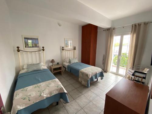 a bedroom with two beds and a window at Annalisa Studio & Apartments in Skala Kefalonias