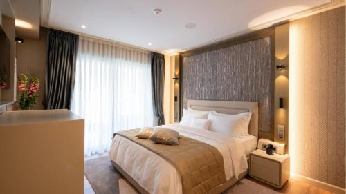 a bedroom with a large bed and a large window at Swiss Diamond Boutique Hotel - La Romantica in Melide