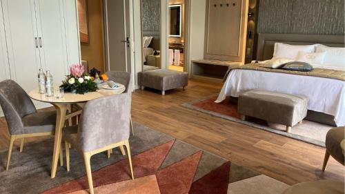 a bedroom with a bed and a table and chairs at Swiss Diamond Boutique Hotel - La Romantica in Melide