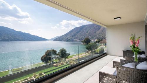 a room with a view of a lake and mountains at Swiss Diamond Boutique Hotel - La Romantica in Melide