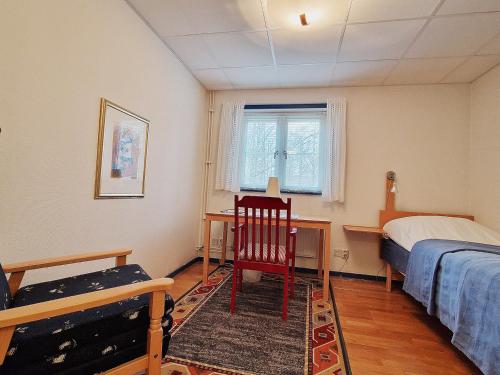 a bedroom with a bed and a chair and a desk at EFS-gården Åsljunga in Åsljunga
