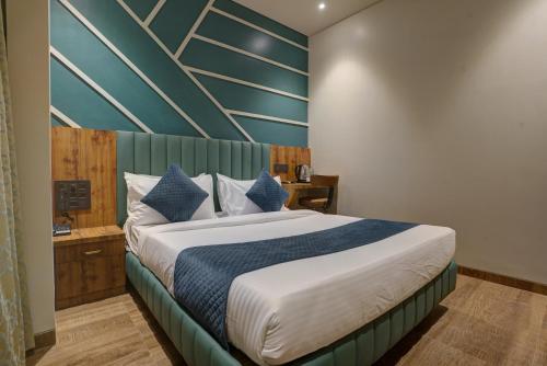 a bedroom with a bed with a blue accent wall at Starville Hotel Andheri MIDC in Mumbai