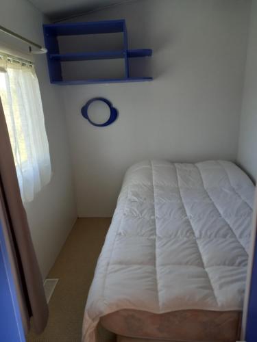 a white bed in a room with a window at les braves in Saint-Laurent-sur-Mer