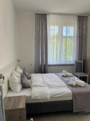a bedroom with a large bed with pillows and a window at Willa WIBOR ulica Tęsknoty 5 Dziwnów in Dziwnów