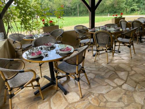 un groupe de tables et de chaises sur une terrasse dans l'établissement Ferme Auberge Du Roc, à Les Vauries