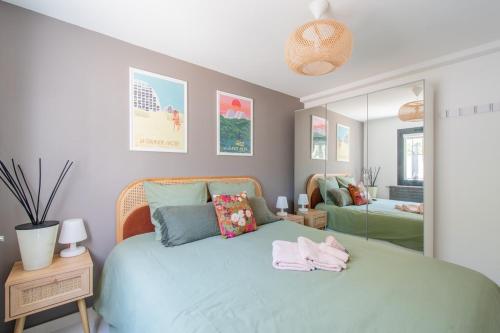 une chambre avec un lit bleu et un miroir dans l'établissement Villa Soléa Beach 2 min Wifi Terrasse air conditionné, à La Grande Motte