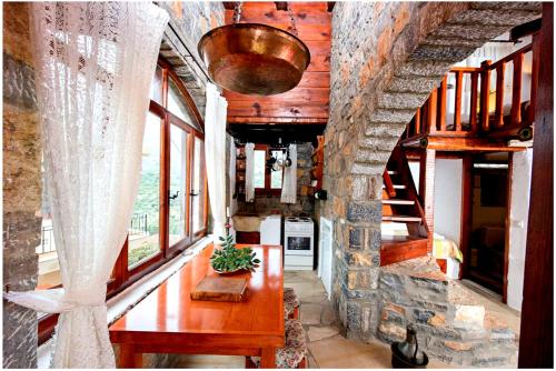 a living room with a table and a stone wall at Elounda Traditional Homes of Crete in Elounda