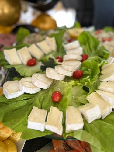 a plate of cheese sandwiches on a lettuce at Hôtel les Paturelles in Avesnelles