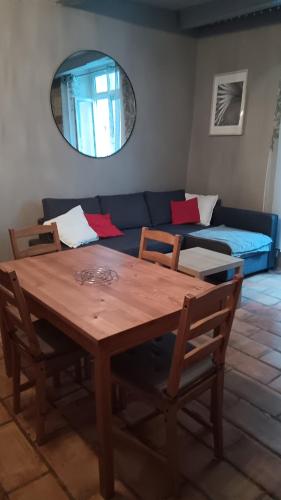 a table and chairs in a living room with a couch at Appartement pour 4 personnes dans une rue très calme in Saint-Laurent-le-Minier