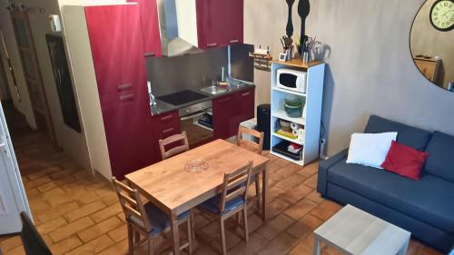 a living room with a table and a blue couch at Appartement pour 4 personnes dans une rue très calme in Saint-Laurent-le-Minier