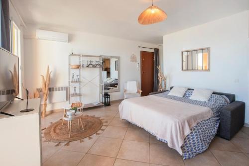 une chambre avec un lit, une table et une télévision dans l'établissement Appartement Vue Mer Proche Plage, à Luri