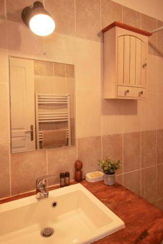 une salle de bain avec un lavabo et un miroir dans l'établissement Appartement Vue Mer Proche Plage, à Luri