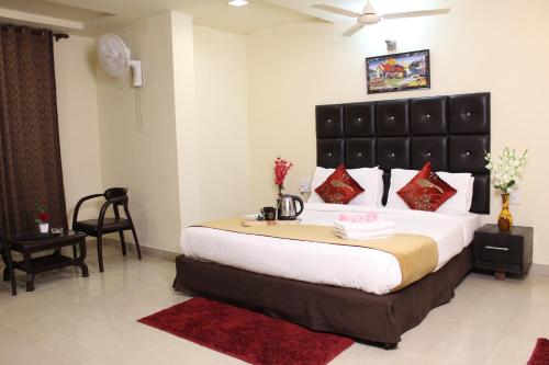 a bedroom with a large bed with a black headboard at ROYAL ROSETTE LAKE VIEW Bhimtal in Nainital