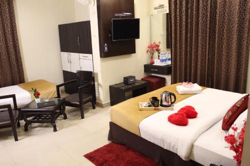a hotel room with two beds with red pillows on them at ROYAL ROSETTE LAKE VIEW Bhimtal in Nainital