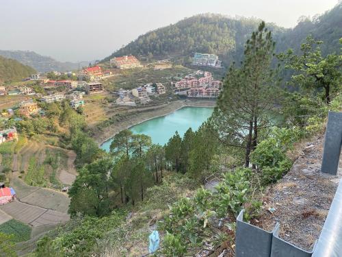 a view of a river with a bridge on a hill at ROYAL ROSETTE LAKE VIEW Bhimtal in Nainital