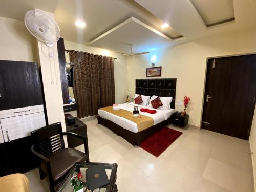 a bedroom with a bed and a chair in it at ROYAL ROSETTE LAKE VIEW Bhimtal in Nainital