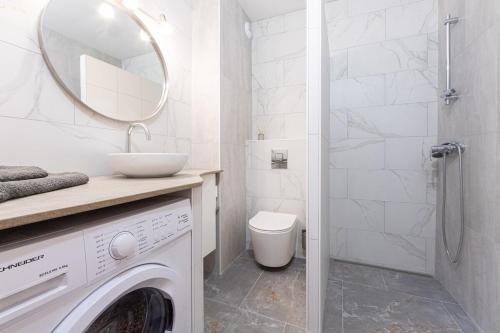 une salle de bain blanche avec une machine à laver et un lavabo dans l'établissement FRGK 