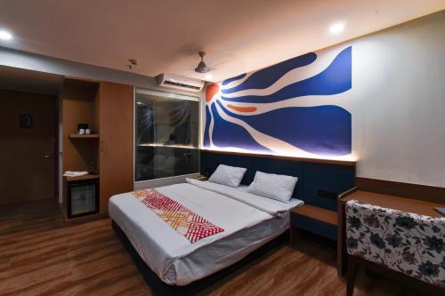 a bedroom with a bed with a blue wall at Ginger Vadodara RCR in Vadodara