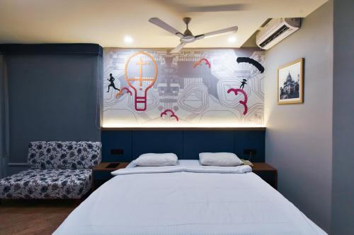 a bedroom with a bed and a wall with a painting at Ginger Vadodara RCR in Vadodara