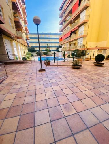 a street light in the middle of a courtyard with buildings at Piso Shic de playa Fenals con terraza y piscina in Lloret de Mar