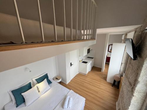 a living room with a white bed and a loft at Ameixial Suites in Porto