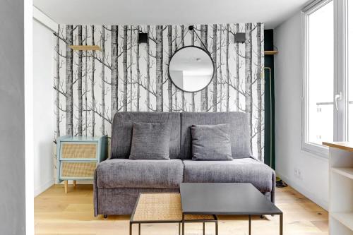 un salon avec un canapé et un miroir dans l'établissement BM-Studio lumineux pour 2 parfait a Paris, à Paris