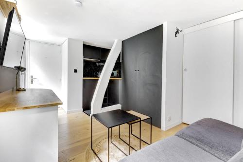 - une chambre avec une table et une chaise à côté d'un lit dans l'établissement BM-Studio lumineux pour 2 parfait a Paris, à Paris
