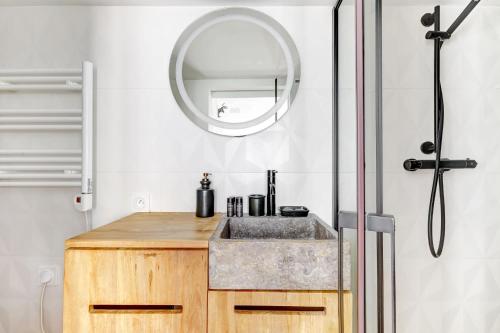 une salle de bain avec un lavabo et un miroir dans l'établissement BM-Studio lumineux pour 2 parfait a Paris, à Paris