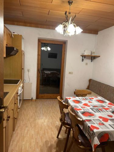 ヒパッハにあるFerienwohnung Schwendbergのテーブルクロスがかけられたテーブルのあるキッチンとダイニングルーム