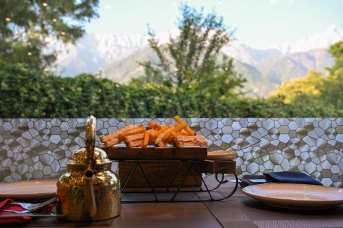 a tray of carrots on a table with a plate of food at White Ridge Hotel in Dharamshala