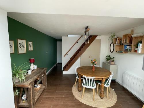 une salle à manger avec une table et un escalier dans l'établissement Chambre chez l habitant avec jardin près de Lille, à Pérenchies
